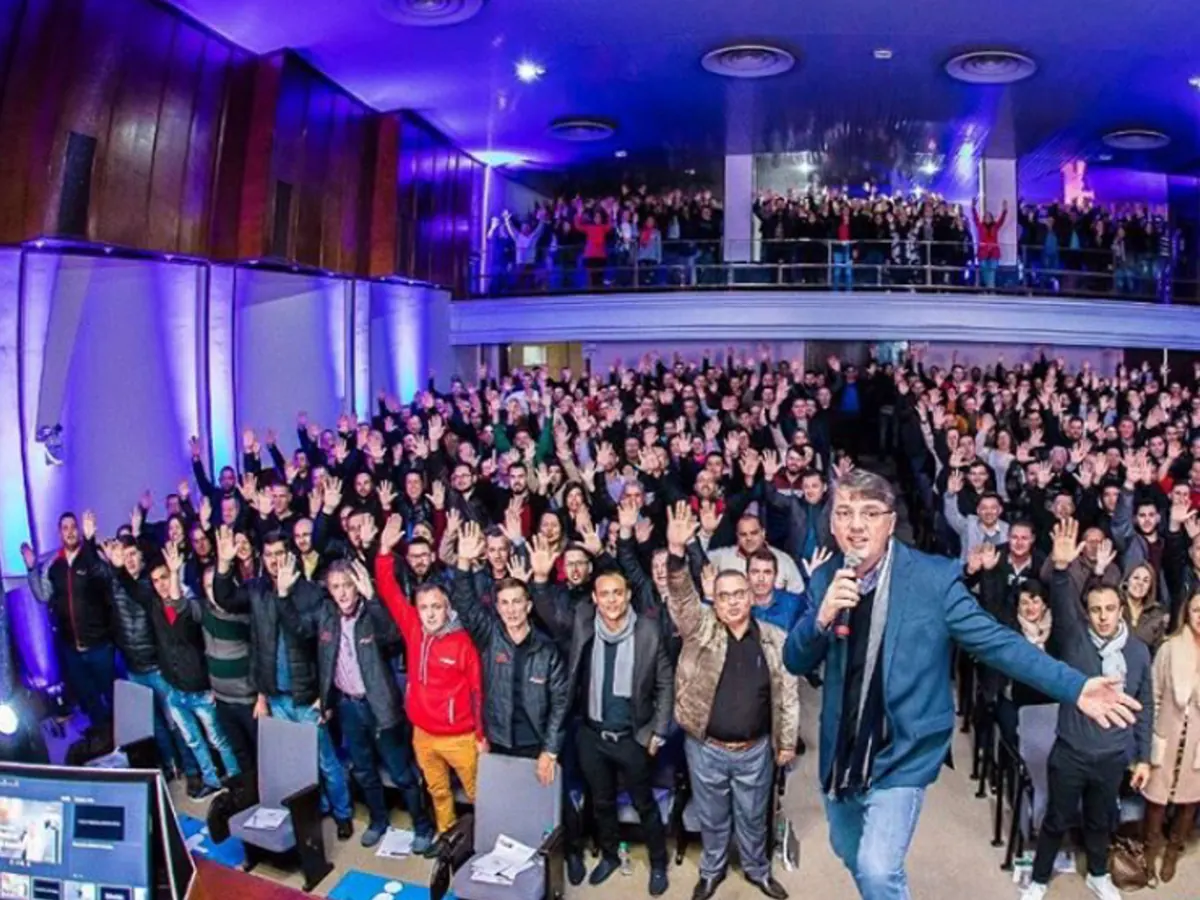Alexandre Guzinski no palco diante de um auditório lotado