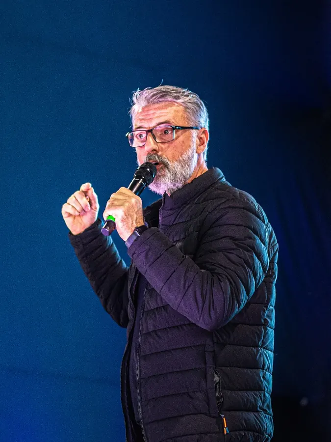 Alexandre Guzinski falando ao microfone em um evento
