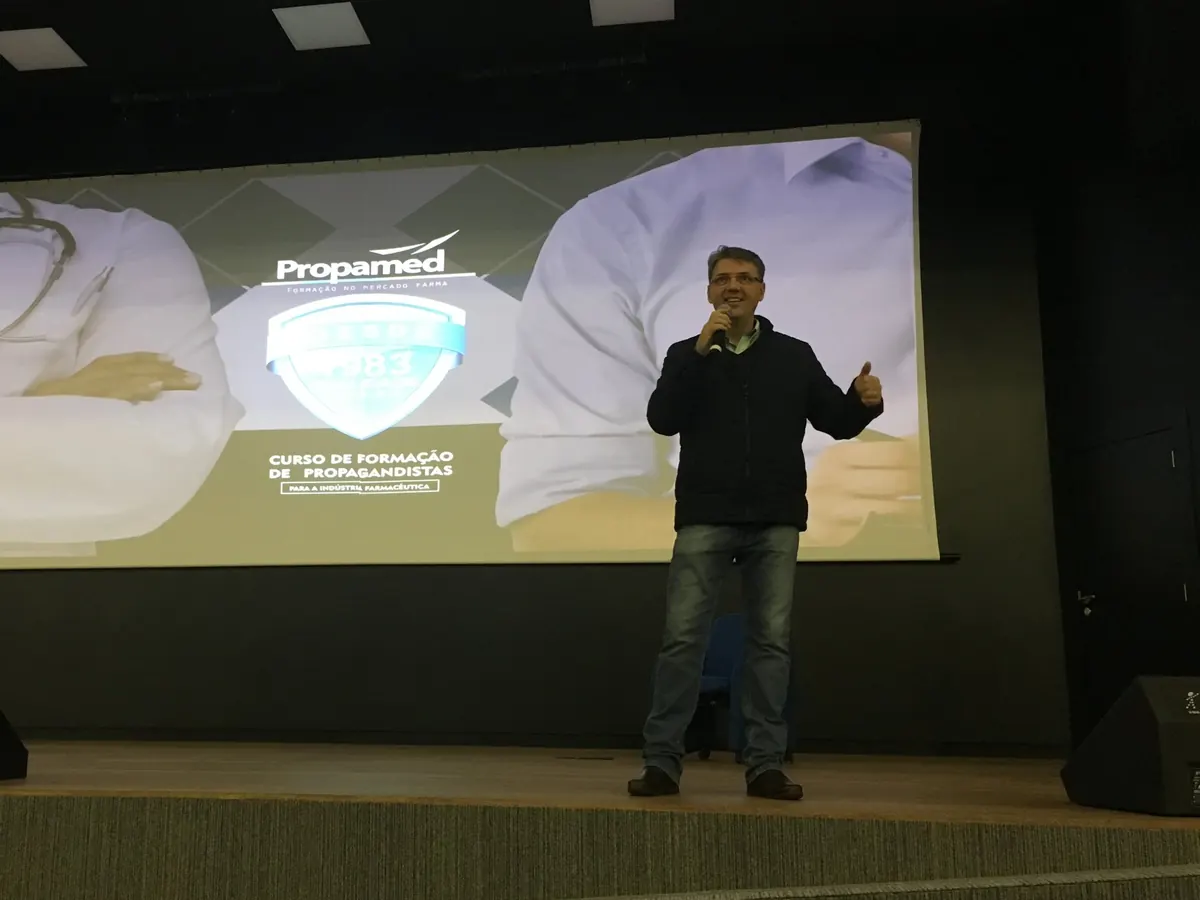 Alexandre Guzinski no palco com o telão do curso da Propamed